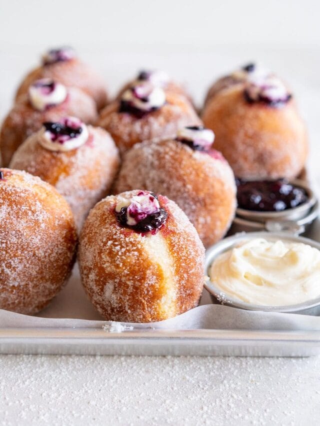 Fluffy doughnuts are fried until perfectly golden brown, then coated in sugar and filled with a whipped vanilla bean cheesecake filling and a balsamic blueberry compote. These are the most perfect treat!