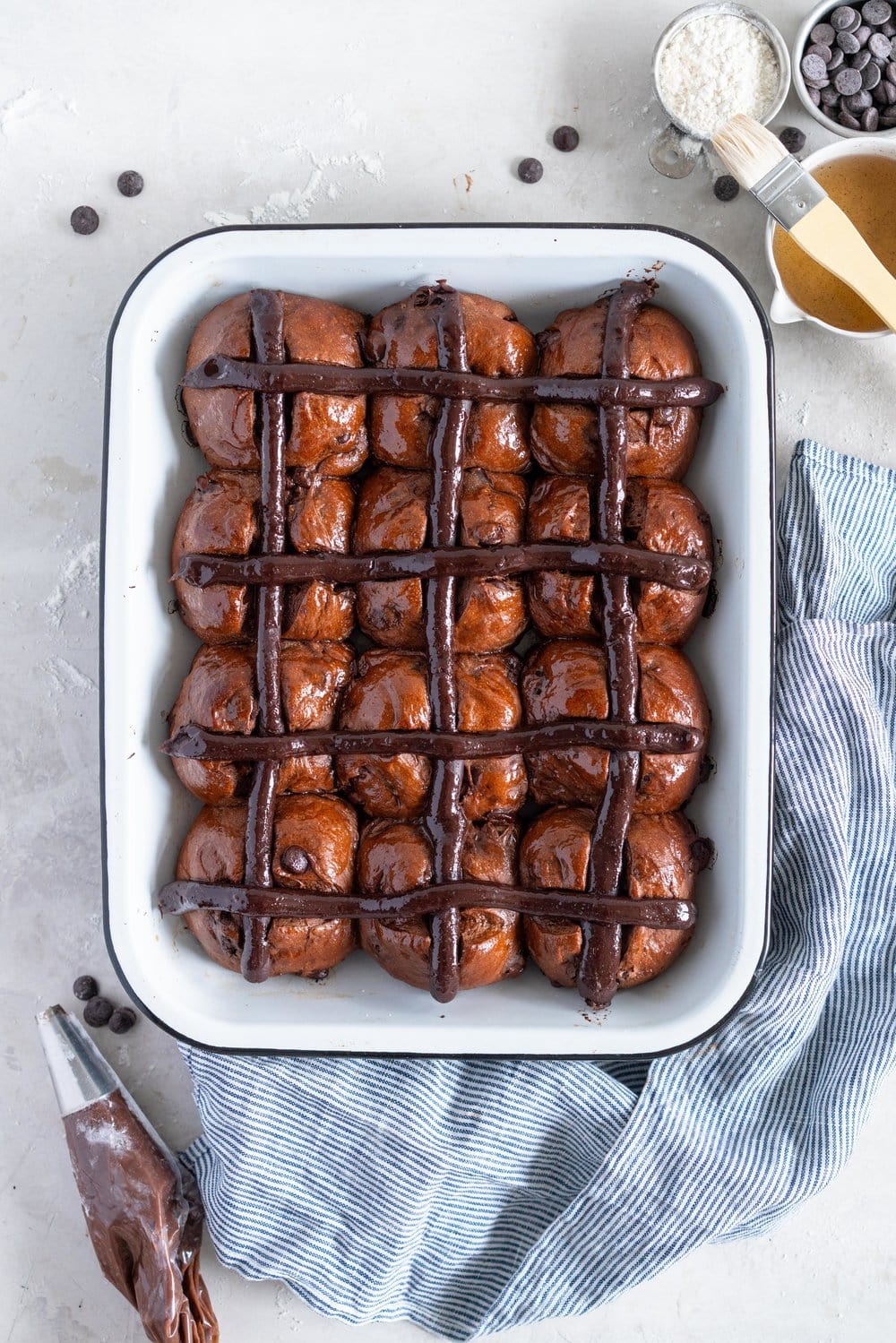 Dark Chocolate and Cardamom Hot Cross Buns with Chocolate Pastry Cream Cross. These are the perfect twist on the traditional hot cross bun - the dough is soft and smooth, and the pastry cream cross adds a beautiful fudgy finish to the bun. These are a must make this Easter! #hotcrossbuns #chocolatehotcrossbun #cardamomhotcrossbun #custardcross