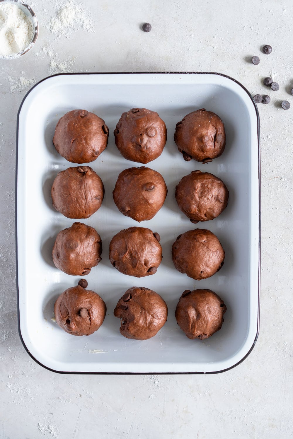 Dark Chocolate and Cardamom Hot Cross Buns with Chocolate Pastry Cream Cross. These are the perfect twist on the traditional hot cross bun - the dough is soft and smooth, and the pastry cream cross adds a beautiful fudgy finish to the bun. These are a must make this Easter! #hotcrossbuns #chocolatehotcrossbun #cardamomhotcrossbun #custardcross