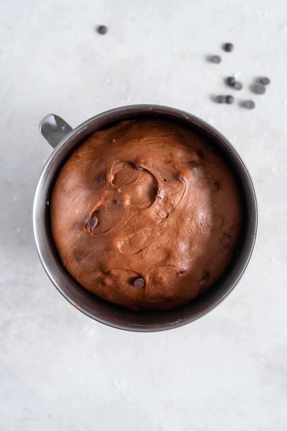 Dark Chocolate and Cardamom Hot Cross Buns with Chocolate Pastry Cream Cross. These are the perfect twist on the traditional hot cross bun - the dough is soft and smooth, and the pastry cream cross adds a beautiful fudgy finish to the bun. These are a must make this Easter! #hotcrossbuns #chocolatehotcrossbun #cardamomhotcrossbun #custardcross