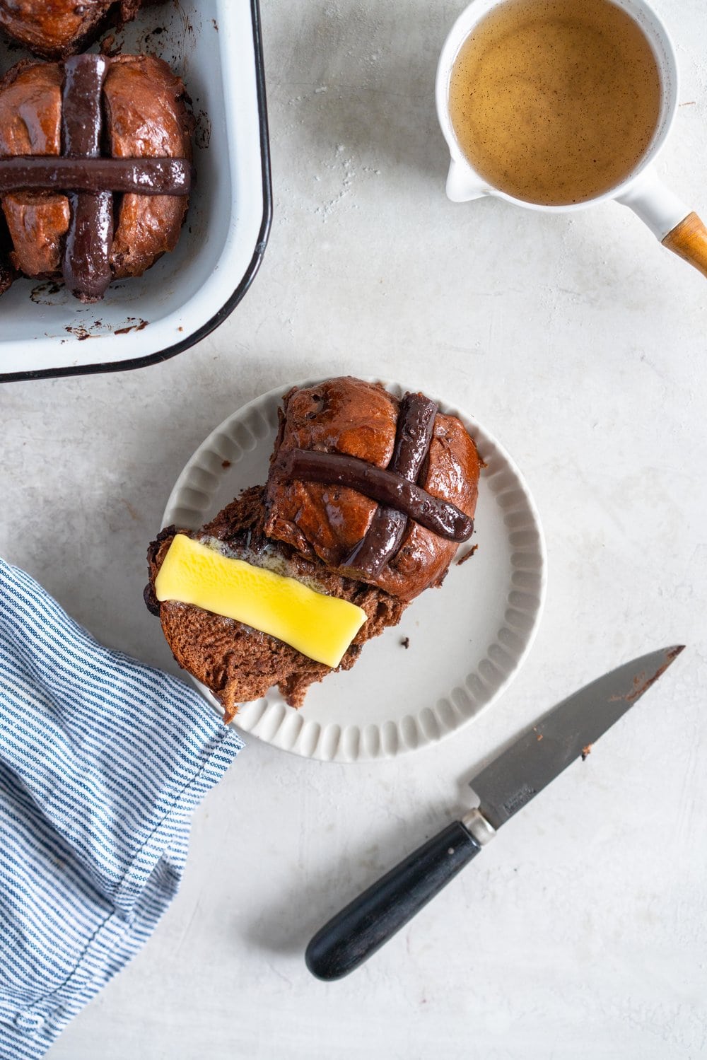 Dark Chocolate and Cardamom Hot Cross Buns with Chocolate Pastry Cream Cross. These are the perfect twist on the traditional hot cross bun - the dough is soft and smooth, and the pastry cream cross adds a beautiful fudgy finish to the bun. These are a must make this Easter! #hotcrossbuns #chocolatehotcrossbun #cardamomhotcrossbun #custardcross