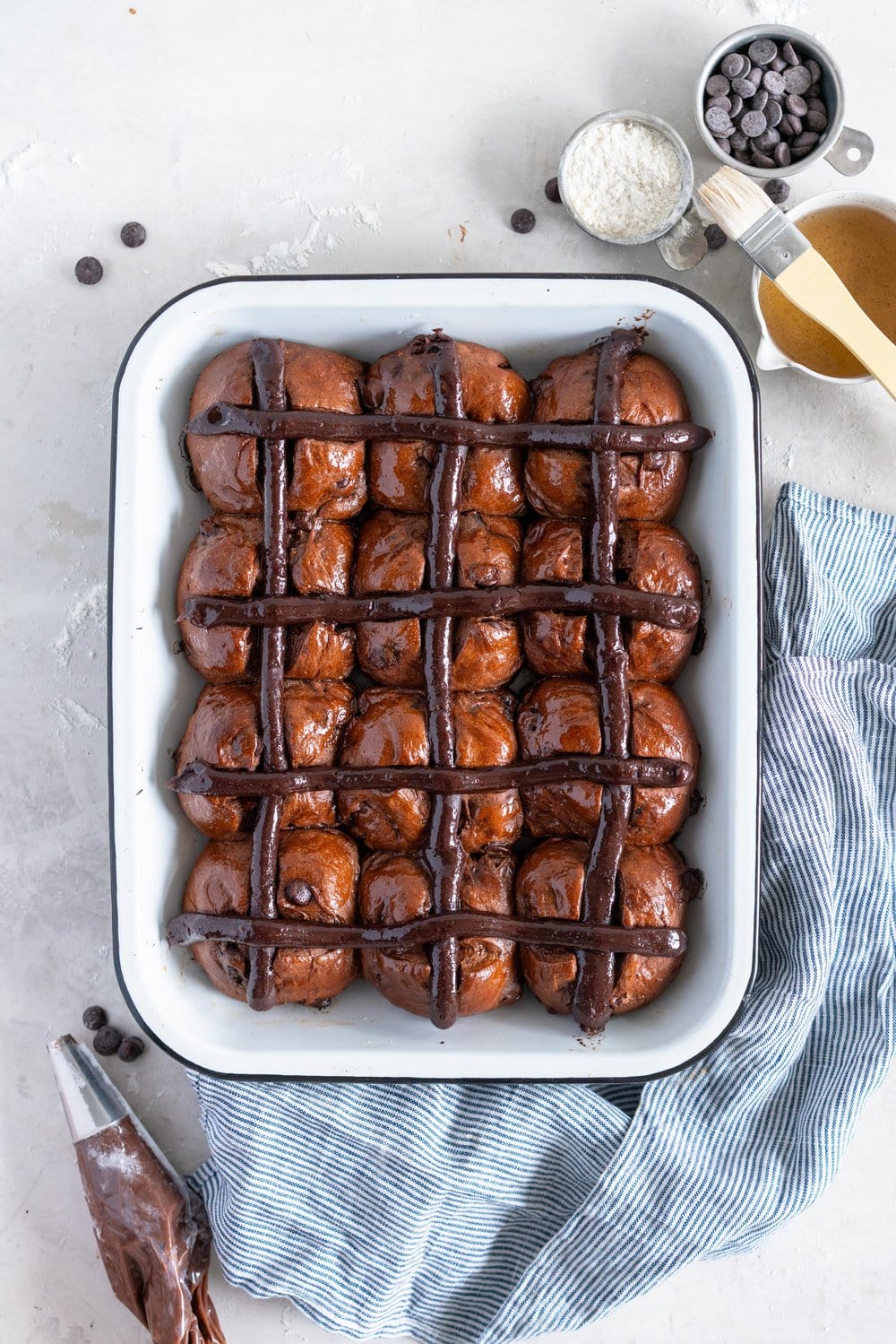 Dark Chocolate and Cardamom Hot Cross Buns with Chocolate Pastry Cream Cross. These are the perfect twist on the traditional hot cross bun - the dough is soft and smooth, and the pastry cream cross adds a beautiful fudgy finish to the bun. These are a must make this Easter! #hotcrossbuns #chocolatehotcrossbun #cardamomhotcrossbun #custardcross