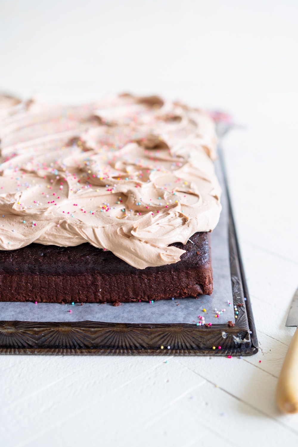 Chocolate sheet cake with milk chocolate german buttercream. This easy, from scratch chocolate sheet cake is enhanced with the flavour of olive oil, and bakes up nice and flat, making it the perfect sheet cake for decorating. It is topped with a silky, milk chocolate german buttercream. #sheetcake #germanbuttercream #chocolateoliveoilcake