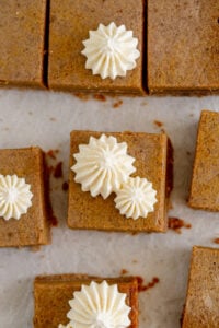 square slice of pumpkin pie bars with whipped cream topping
