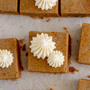 square slice of pumpkin pie bars with whipped cream topping
