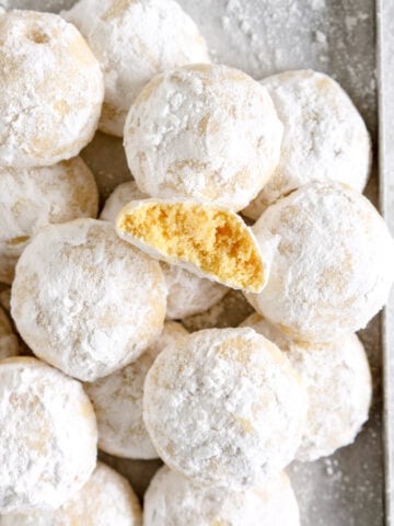 pan of snowball cookies with one broken open