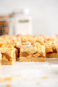 side on shot of apple pie bars with powdered sugar