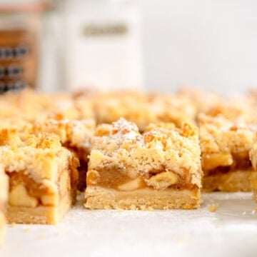 side on shot of apple pie bars with powdered sugar