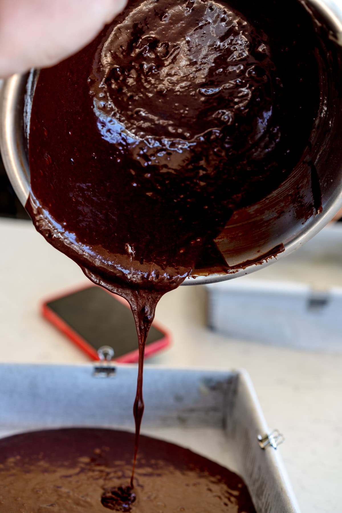 adding brownie batter to pan