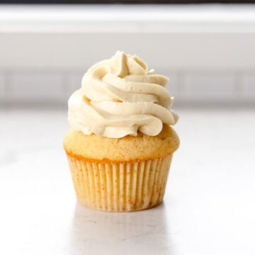 vanilla frosting piped on a cupcake